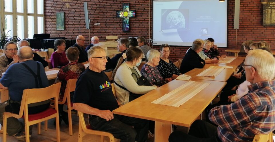 eläkekerholaisia pitkän pöydän ääressä